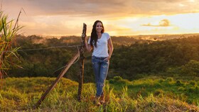 Catalina Vélez saulėtame lauke palydi saulėlydį