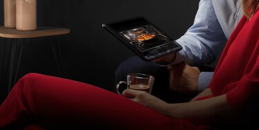 Man showing woman an oven on a tablet